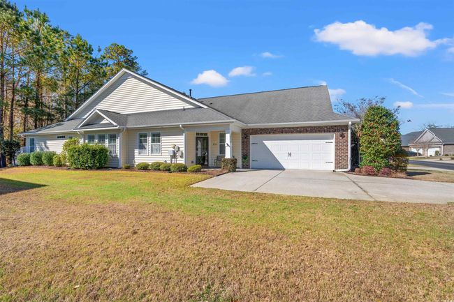 View of front of property featuring an attached garage, a front lawn, concrete driveway, and roof with shingles | Image 24