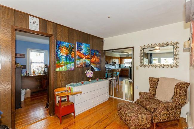 Living area featuring a baseboard radiator and wood finished floors | Image 9