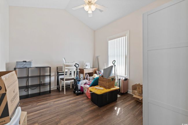 Sitting room featuring a ceiling fan, vaulted ceiling, wood finished floors, and baseboards | Image 12