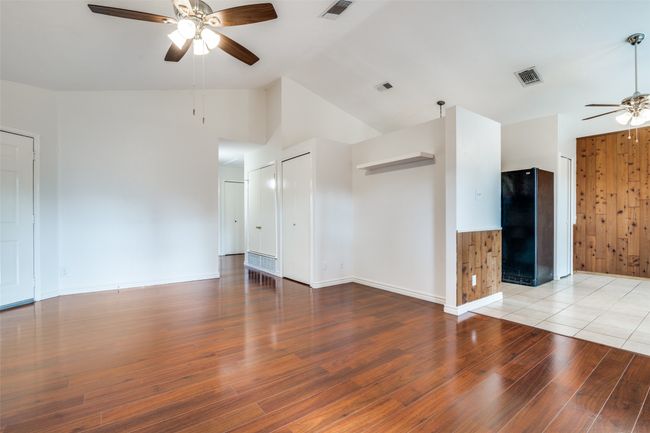 Unfurnished living room featuring a ceiling fan, light wood-style floors, and vaulted ceiling | Image 8