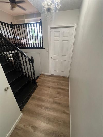 Entrance foyer featuring hardwood / wood-style flooring, a textured ceiling, and ceiling fan with notable chandelier | Image 2