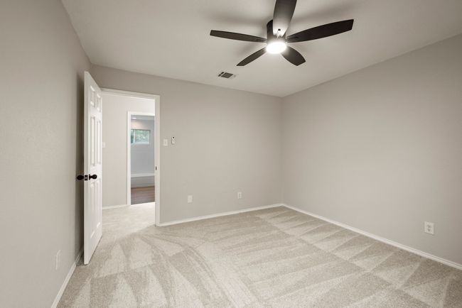 All of the bedrooms are spacious with large windows, fresh carpet, and modern ceiling fans. | Image 33