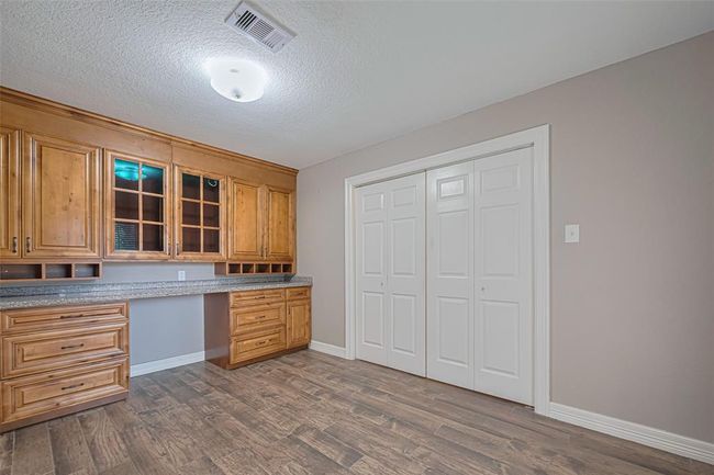 Front room off of entry offers lots of natural lighting, storage, custom built-in wood cabinetry/desk, and double entry privacy doors that makes this perfect for office/study/hobby room | Image 5