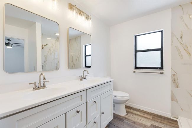 Your private retreat — the primary bathroom features stylish tilework, modern lighting, and a sleek vanity | Image 7