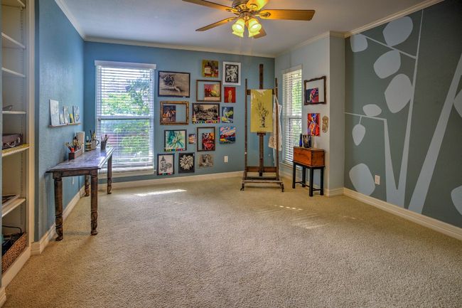 Bedroom with baseboards, built-in shelving, carpet floors, ornamental molding, and a ceiling fan | Image 35
