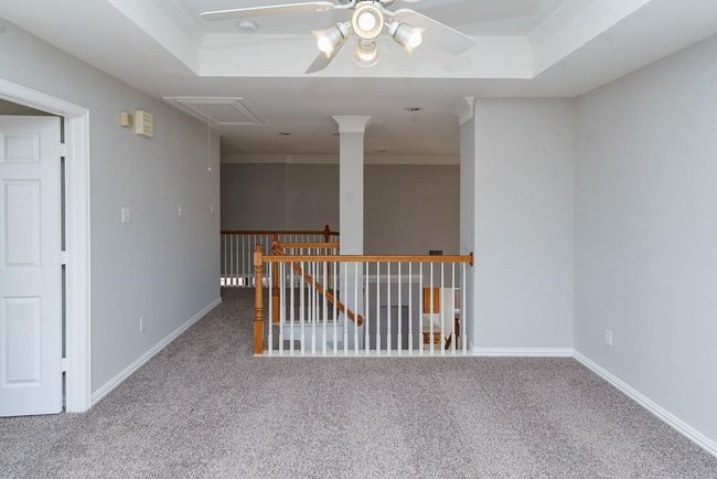 Unfurnished room featuring carpet, attic access, ornamental molding, and a raised ceiling | Image 16