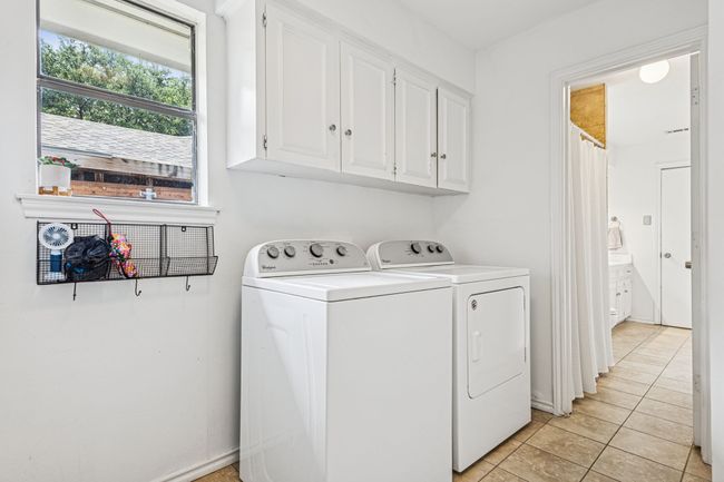 Laundry room with cabinet space, washing machine and clothes dryer, and light tile patterned floors | Image 22