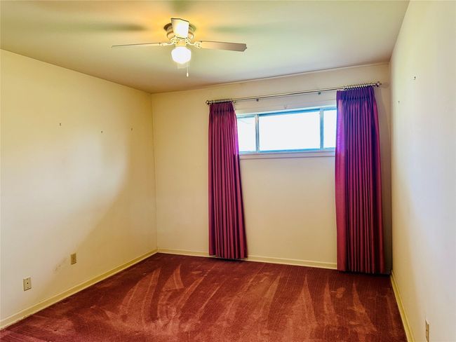 Carpeted spare room featuring a ceiling fan and baseboards | Image 11