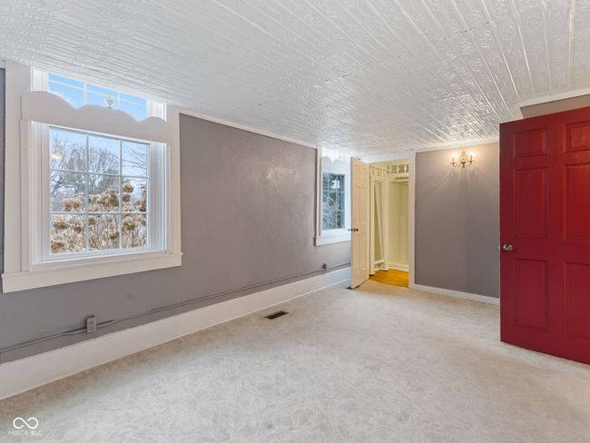 carpeted empty room featuring plenty of natural light, baseboards, and visible vents | Image 19