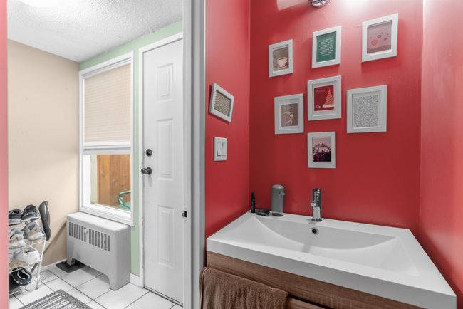Bathroom featuring radiator heating unit, tile patterned flooring, a textured ceiling, and baseboards | Image 9