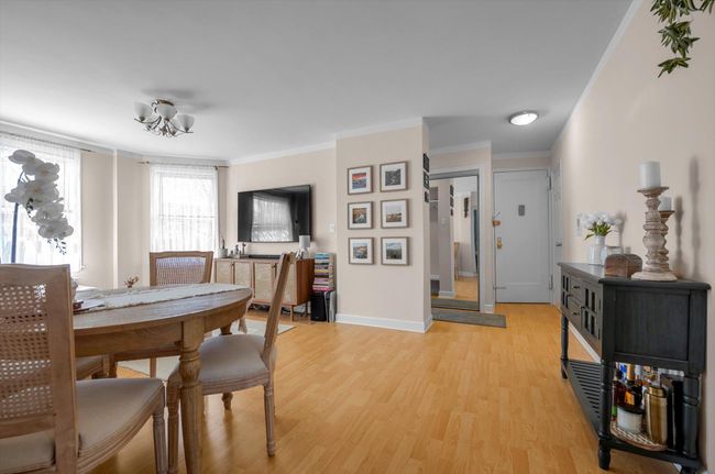 Dining space with light wood finished floors, baseboards, and crown molding | Image 5