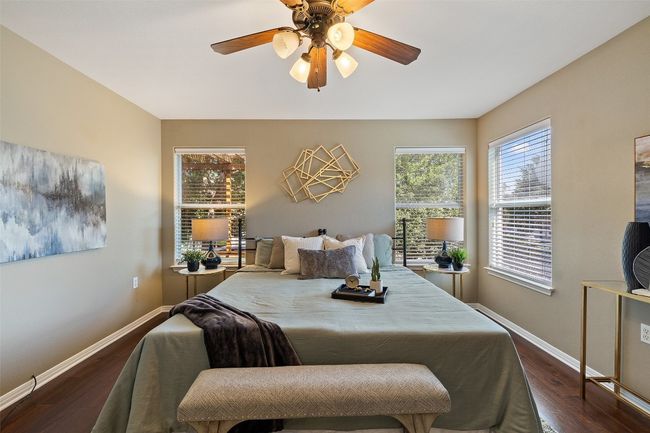 Bedroom with dark wood-style flooring, baseboards, and ceiling fan | Image 4
