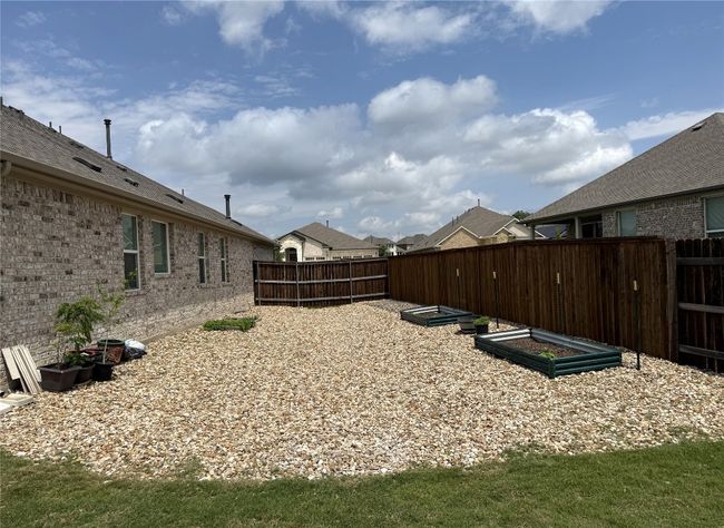 Fenced backyard featuring a vegetable garden | Image 32