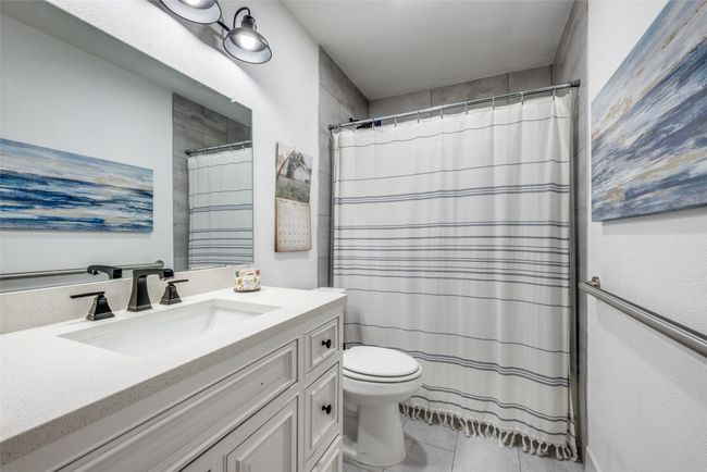 Bathroom with tile patterned flooring, toilet, vanity, and a shower with curtain | Image 21