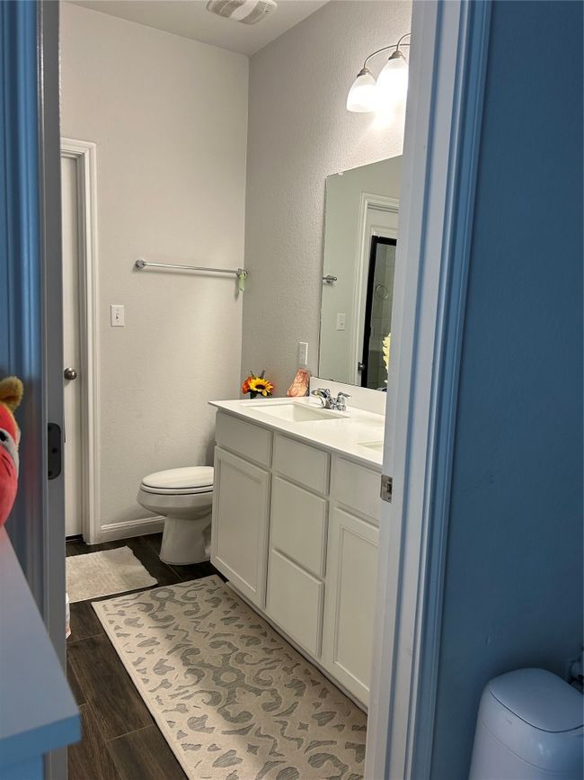 Bathroom with vanity, wood finished floors, visible vents, and toilet | Image 18