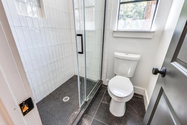 Full bathroom featuring tile patterned floors, baseboards, a shower stall, and toilet | Image 21