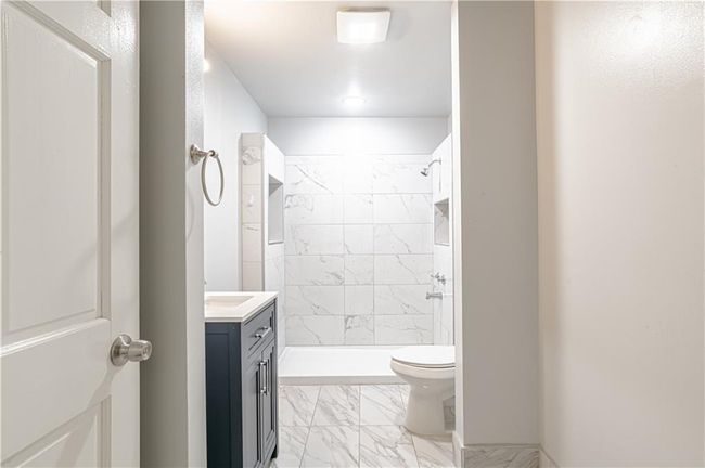 Bathroom featuring vanity, toilet, and a tile shower | Image 30
