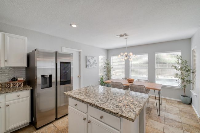 Kitchen with stainless steel refrigerator with ice dispenser, a chandelier, healthy amount of natural light, a center island, and recessed lighting | Image 8