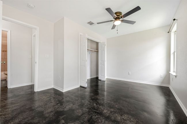 Unfurnished bedroom featuring finished concrete floors, a closet, and a ceiling fan | Image 17