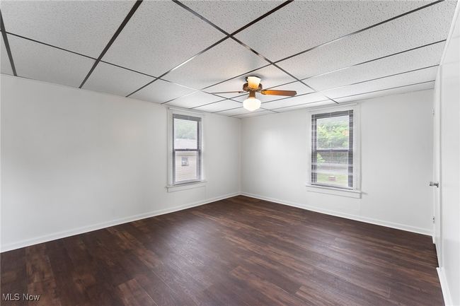 Unfurnished room featuring plenty of natural light, wood finished floors, and a paneled ceiling | Image 16