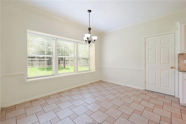Empty room featuring crown molding, a chandelier, and baseboards | Image 11