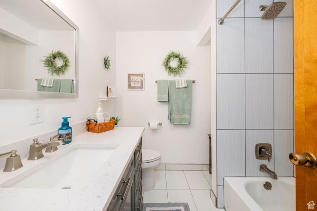 Full bath with vanity, toilet, tile patterned floors, and shower / tub combination | Image 28