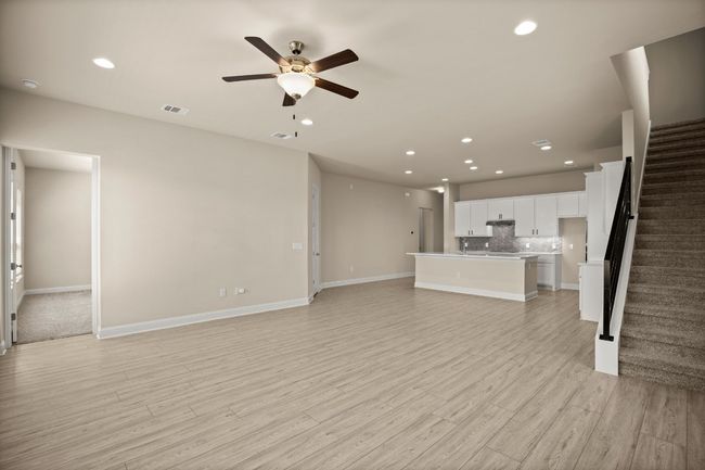 Unfurnished living room with ceiling fan, stairs, visible vents, and recessed lighting | Image 7