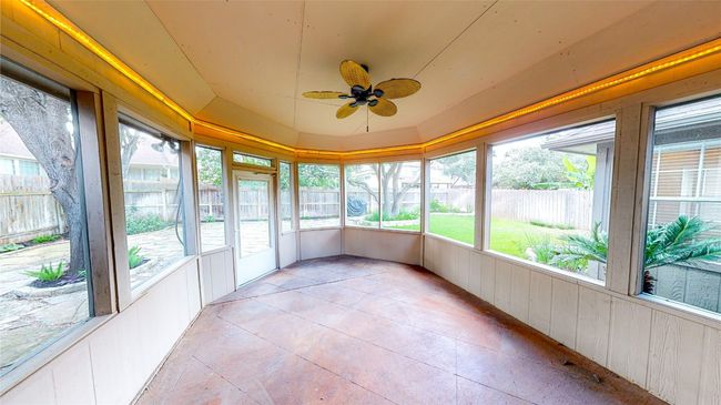 Unfurnished sunroom with ceiling fan and vaulted ceiling | Image 8