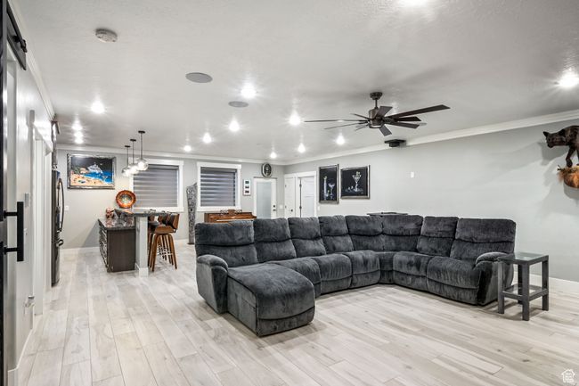 Living area with crown molding, light wood-type flooring, ceiling fan, and recessed lighting | Image 62