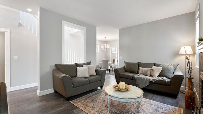 Living area featuring dark wood-style floors, baseboards, an inviting chandelier, recessed lighting, and stairs | Image 5