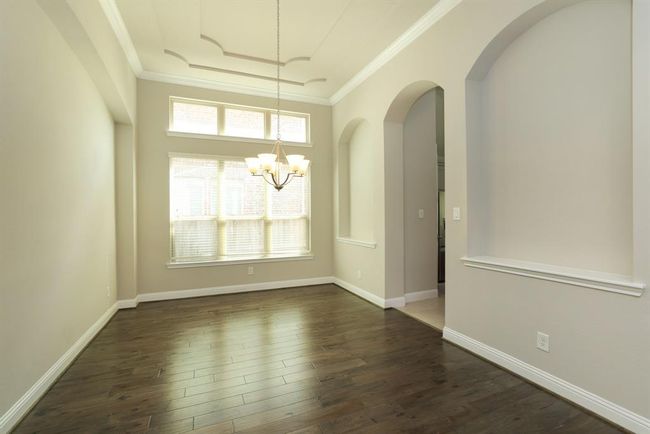 Spacious dining room with kitchen entrance and art niche | Image 7