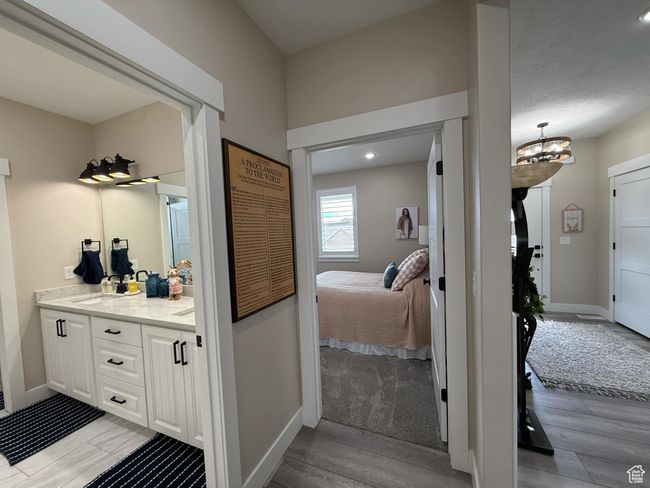 Bathroom with baseboards, connected bathroom, wood finished floors, vanity, and an inviting chandelier | Image 57