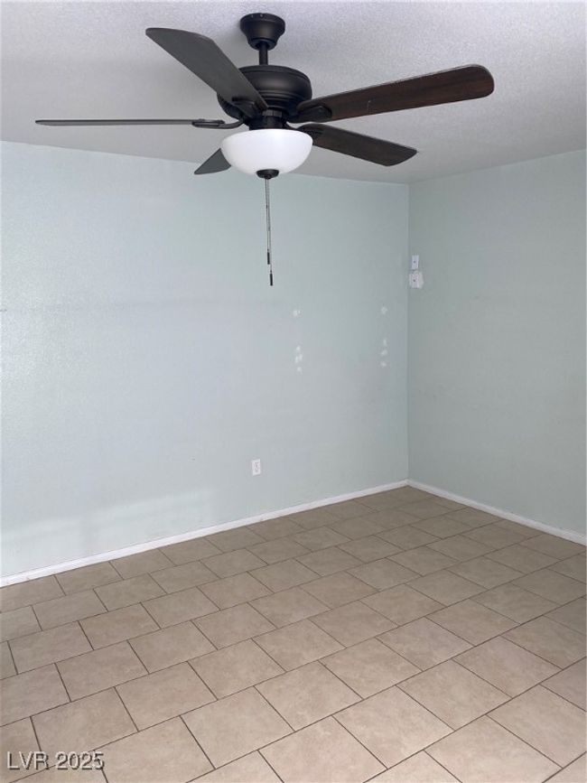 Empty room with ceiling fan and a textured ceiling | Image 6