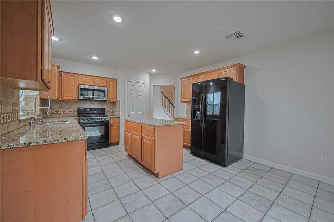 Spacious kitchen with granite countertops, breakfast area overlooking the large front and side yard, and refrigerator included! | Image 12