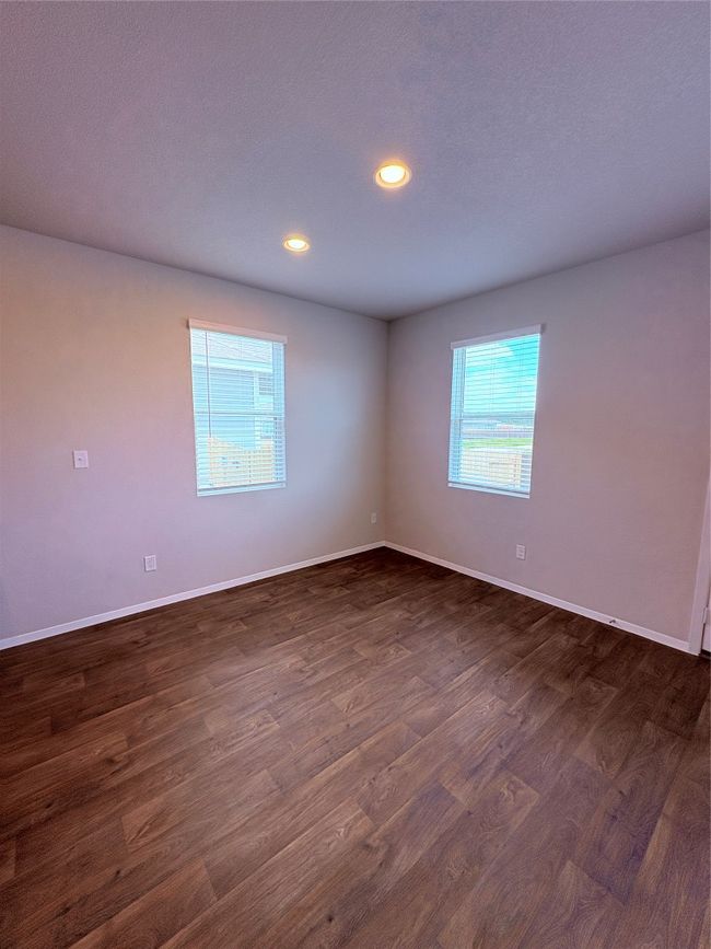 Empty room with dark wood finished floors, baseboards, and recessed lighting | Image 7