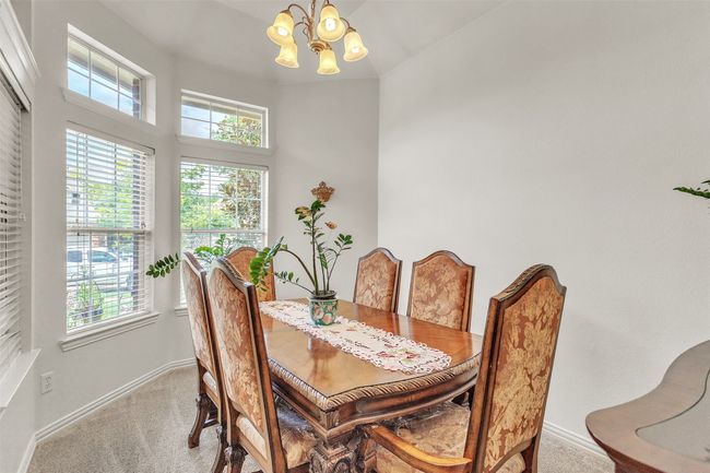 Dining room with light carpet, a chandelier, and plenty of natural light | Image 8