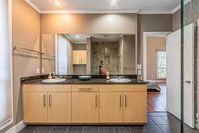 Full bathroom with ornamental molding, double vanity, a stall shower, and tile patterned floors | Image 23