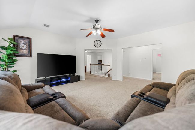 Living area with carpet, ceiling fan, baseboards, and lofted ceiling | Image 28