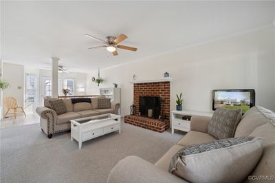 Carpeted living room with ceiling fan, ornamental molding, and a fireplace | Image 3