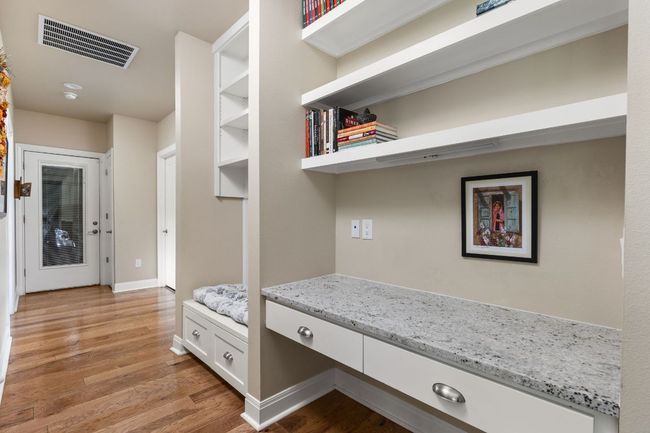 Adjacent to the kitchen, a built-in desk area provides a convenient space for organization or work. | Image 24