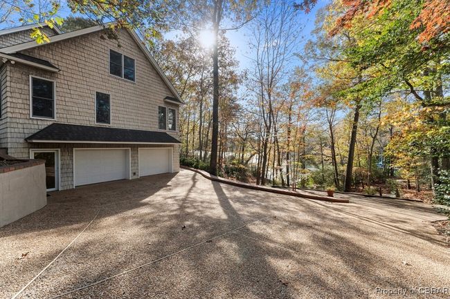 View of home's exterior featuring a garage and driveway | Image 49