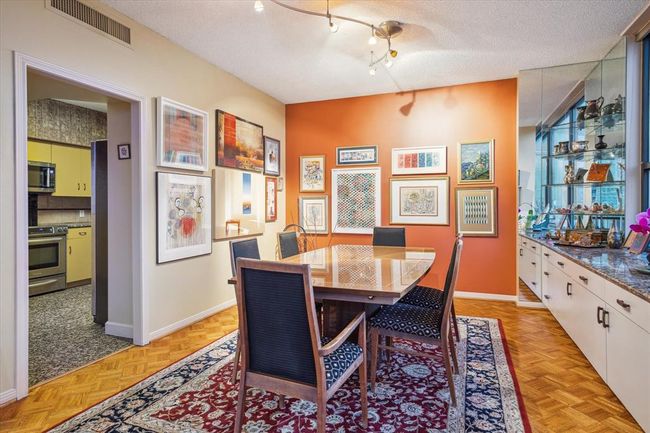 A beautiful dining room featuring sleek track lighting and a built-in buffet area with a striking granite countertop. | Image 9