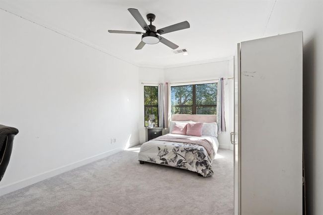 Charming secondary bedroom with a bay window, plush carpet, and easy access to a Jack and Jill bathroom, perfect for shared living. | Image 36