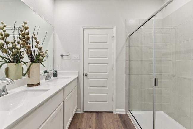 Full bath featuring a shower stall, wood finished floors, and double vanity | Image 8