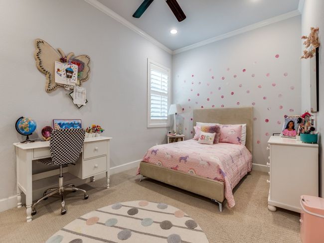 Bedroom with crown molding, light colored carpet, baseboards, ceiling fan, and a desk | Image 15