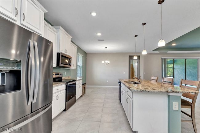 Kitchen with visible vents, baseboards, an inviting chandelier, a sink, and appliances with stainless steel finishes | Image 27
