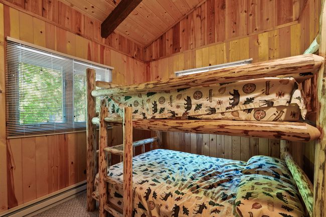 Bedroom featuring a baseboard heating unit, wooden walls, and wood ceiling | Image 9