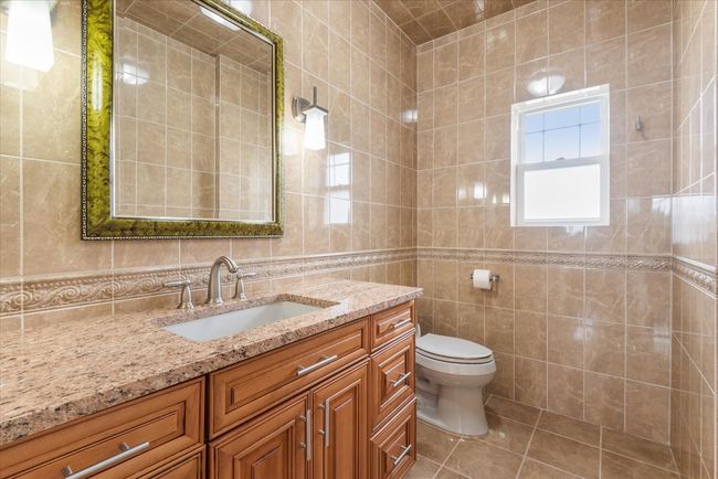 Bathroom featuring vanity, tile walls, toilet, and tile patterned floors | Image 7