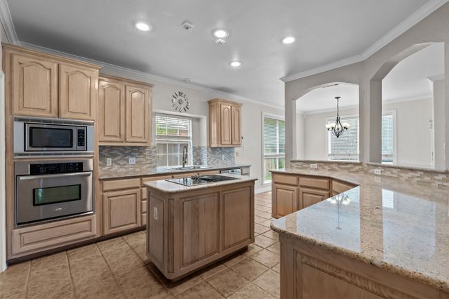 Chef's kitchen featuring stainless appliances, center island, breakfast bar and granite counters | Image 11