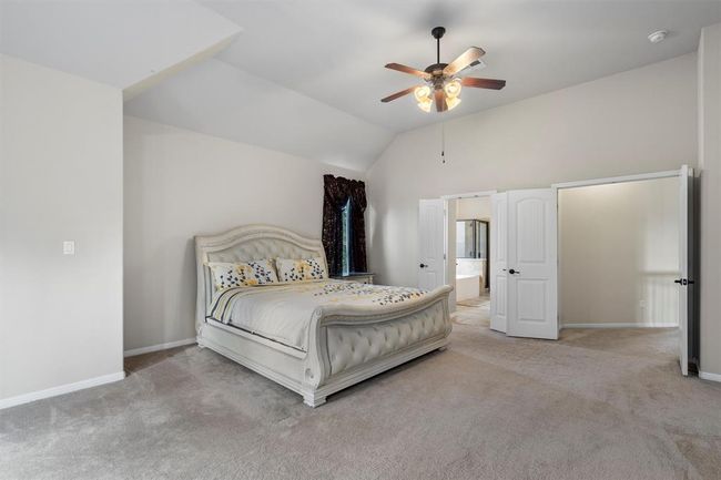 Bedroom with carpet flooring, baseboards, lofted ceiling, and ceiling fan | Image 21